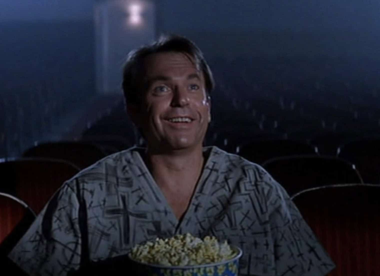 Sam Neill som sit i kinosal i skrekkfilmen In the mouth of madness av John Carpenter