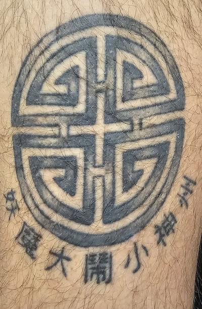 Ein tatovering av Big Trouble In Little China-symbol på Ators hånd.