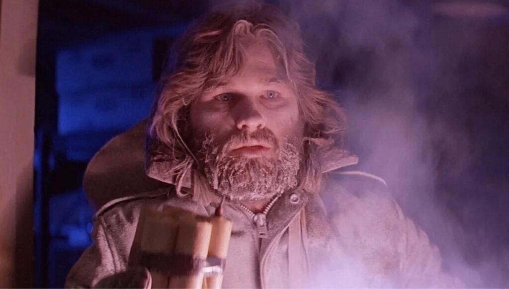 Kurt Russell som MacReady omringet av kulde og fiender fra filmen Tingen fra en annen verden (1982)