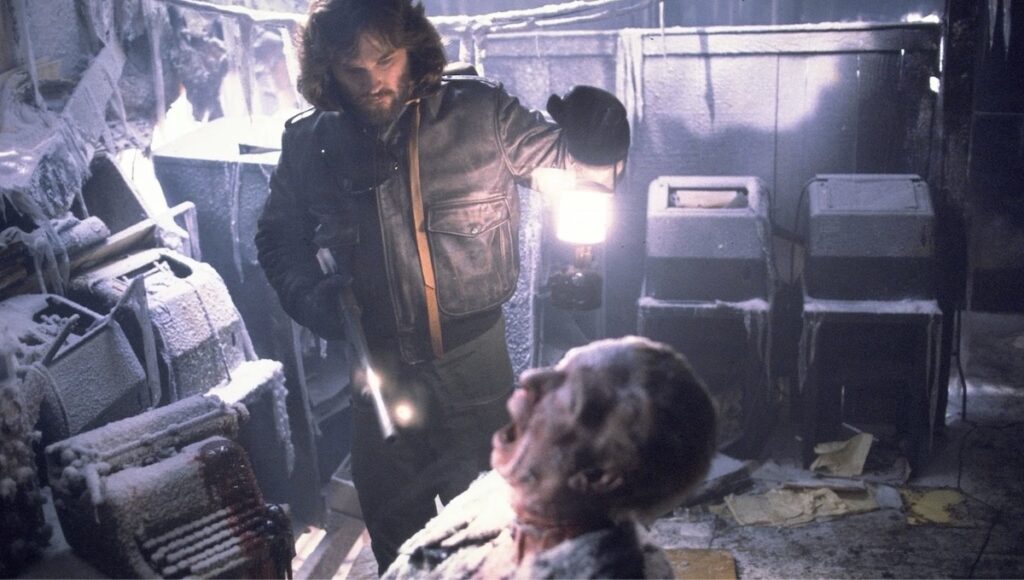 Kurt Russell spelar MacReady som her utforskar den norske basen i John Carpenters The Thing (1982)