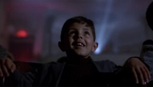 Ein gut sitt og ser på film i kinoen frå filmen Cinema Paradiso (1988)