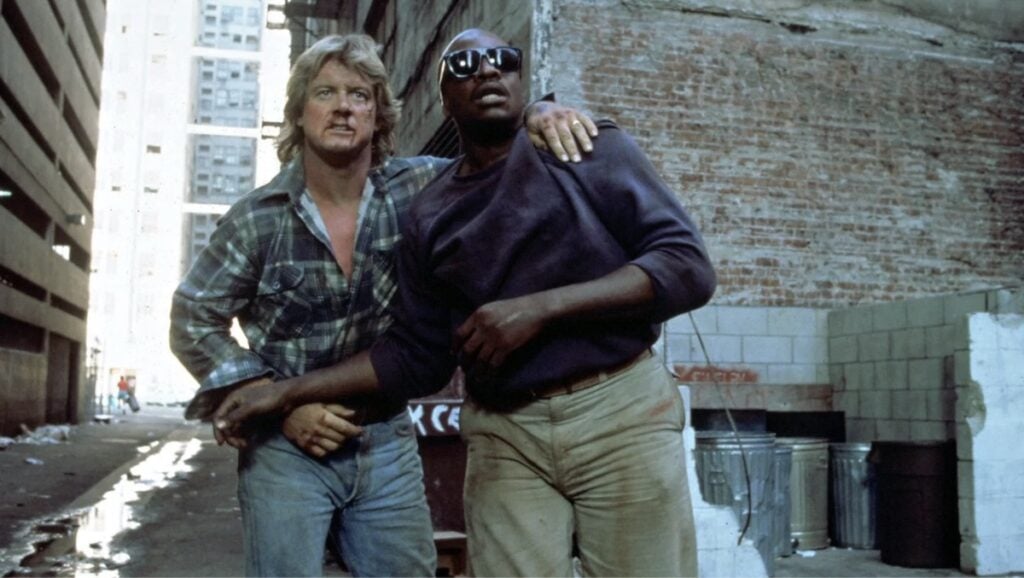 Roddy Piper og Keith David rett etter slagsmålet frå den ikoniske John Carpenter filmen They Live (1988)