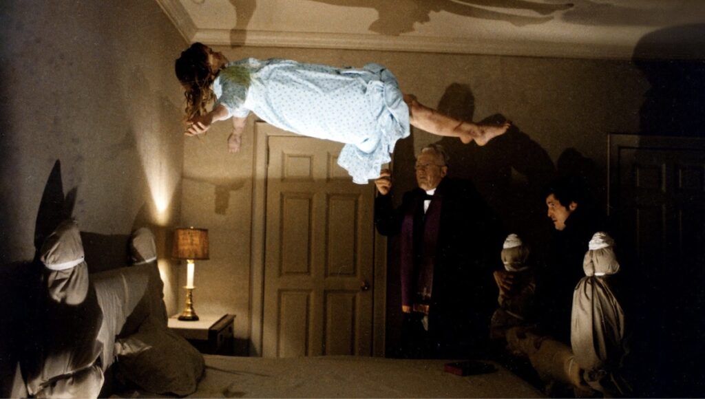Linda Blair flyr opp i taket foran prestane, frå skrekkfilmen The Exorcist (1973).