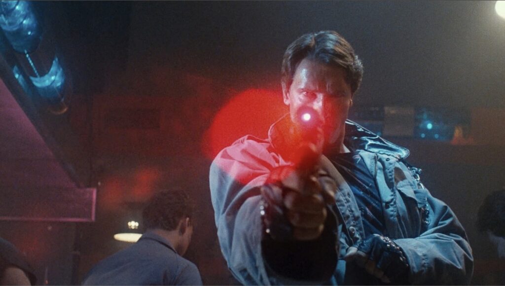 Arnold Schwarzenegger som T-800 med lasersikte-pistol i filmen The Terminator.