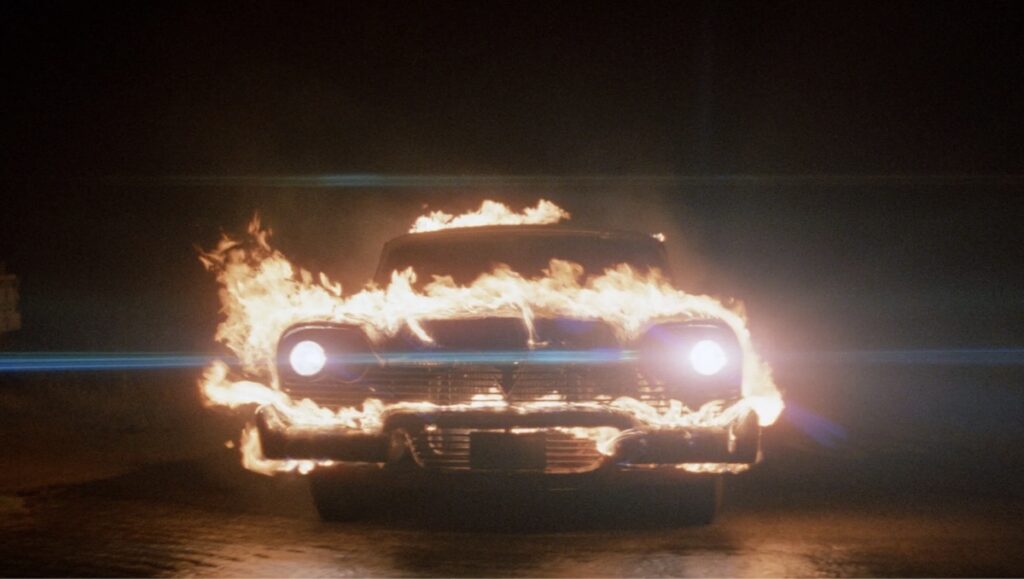 Christine i flammer frå John Carpenters skrekkfilm, Christine (1983).