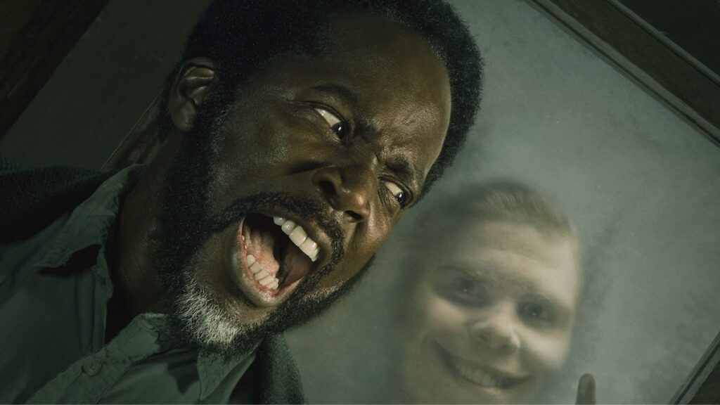 Harold Perrineau med eit smilandes monster bak seg, frå tv-seria From.