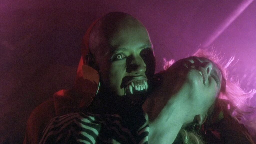 Grace Jones som vampyrdronningen Katrina med ekstrem sminke og hoggtenner i filmen Vamp frå 1986.
