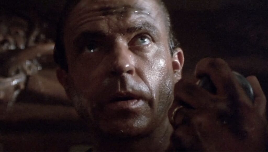 Sam Neill som er forlatt på eit synkandes skip og kontaktar kona på radio, frå filmen Dead Calm (1989).