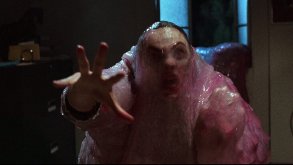 Ein mann som er fanga av monsteret The Blob (1988).