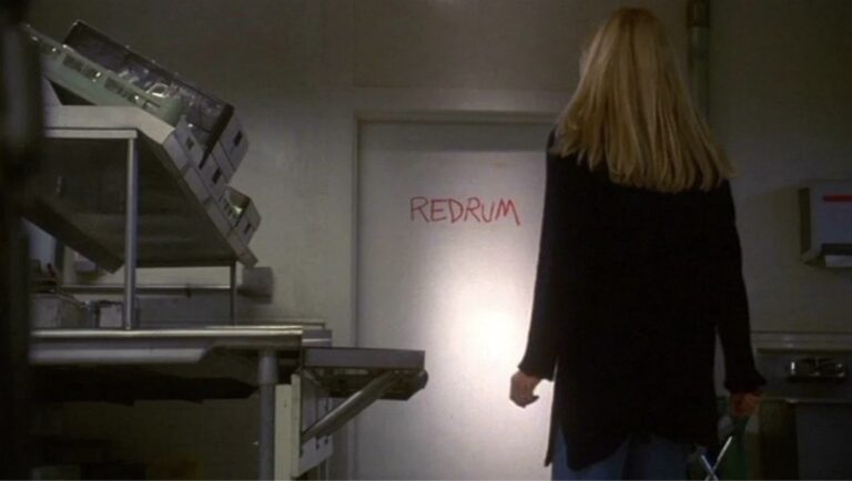 Rebecca De Mornay står med ryggen til og les orda "Redrum" frå miniserien The Shining (1997)